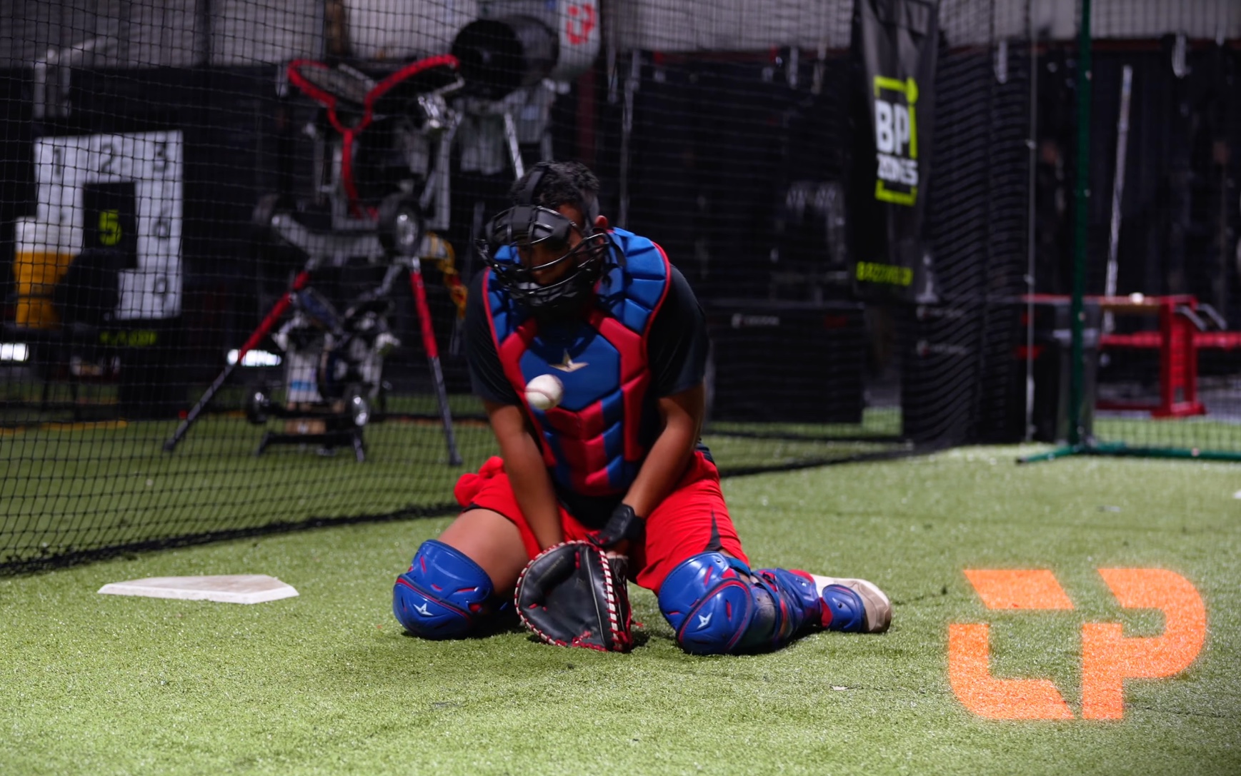 A catcher practicing blocking during a CATCHPRO training session